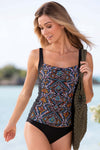 Woman in a patterned tank top and black shorts walking by a body of water.